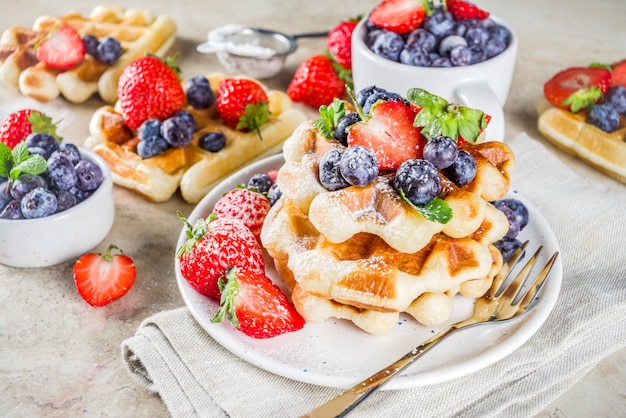 Süße selbst gemachte belgische Waffeln mit Beeren