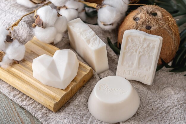 Süße Stücke weißer Naturseife Seifenschale Kokosnuss und Baumwolle auf dem Tisch