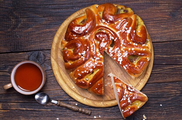 Süße Torte mit Marmelade und Tasse Tee auf Holztisch, Ansicht von oben