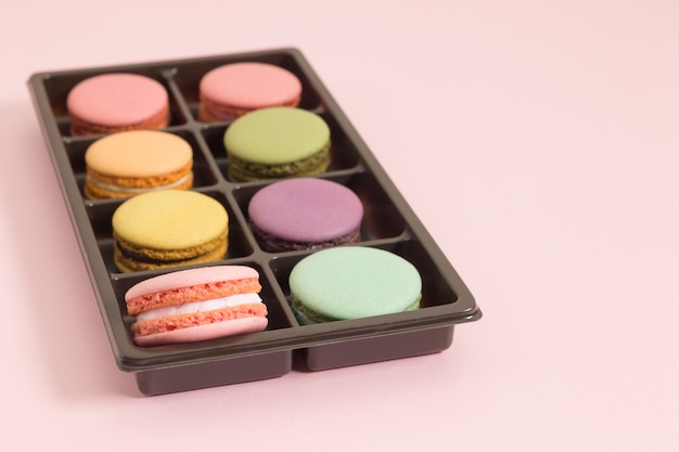 Süße und bunte französische Makronen oder macaron auf rosa Hintergrund, Nachtisch.