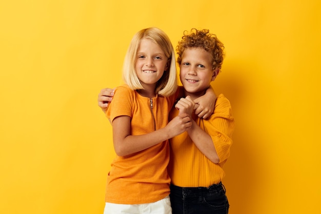 Süße Vorschulkinder Freizeitkleidung Spiele Spaß zusammen posieren auf farbigem Hintergrund