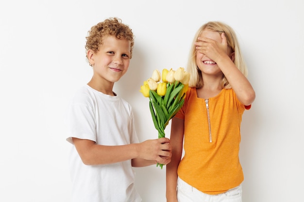 Süße Vorschulkinder Urlaub Freundschaft mit einem Geschenk Gelbe Blumen Lebensstil unverändert