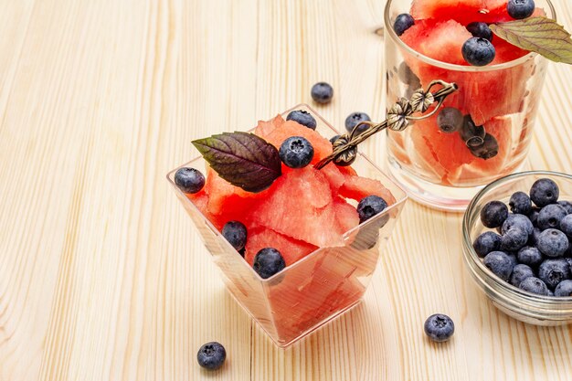 Süße Wassermelone mit Blaubeeren und purpurroten Basilikumblättern