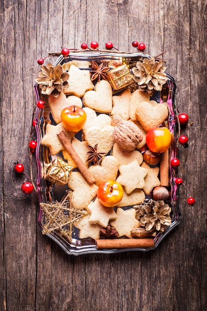 Süße Weihnachtsdekoration - Kekse, Apfel und Gewürze auf dem Tablett