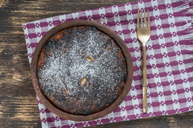 Süßer Auflauf mit verbrannter Kruste auf Holztisch. Keramikschale mit gebackenem Hüttenkäse-Auflauf, Nahaufnahme, Ansicht von oben