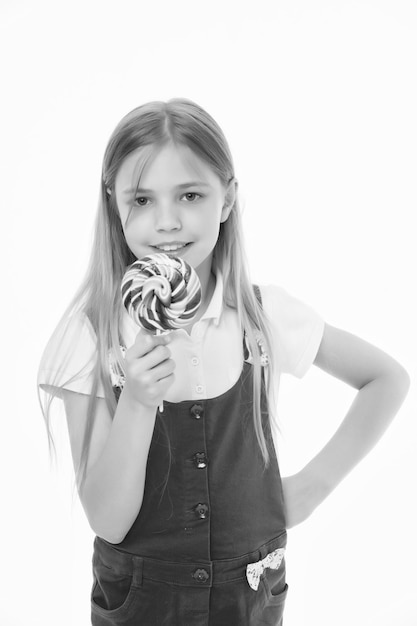 Süßer Blick Kleines Mädchen essen Süßigkeiten auf Stick, isoliert auf weiss Kinderlächeln mit Lollipop Glückliches Kind mit Swirl Karamell Essen und Nachtisch Diät und Diät