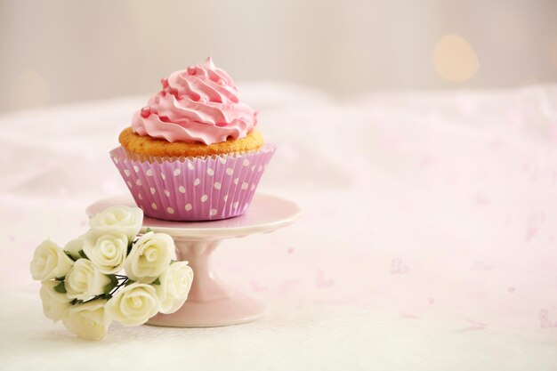 Süßer Cupcake auf dem Tisch auf hellem Hintergrund