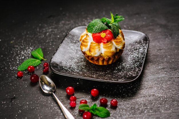 Süßer Cupcake mit Cranberry auf schwarzem Hintergrund