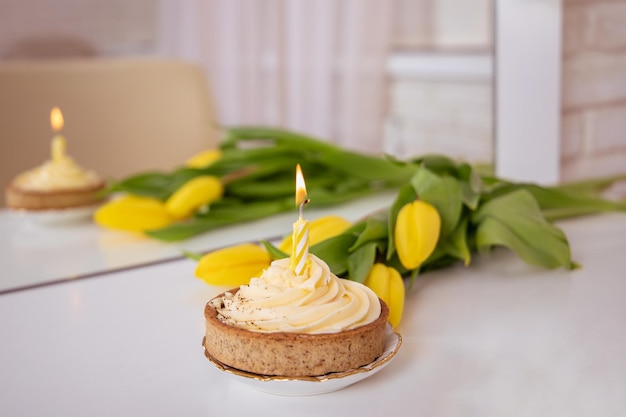 Süßer Geburtstagskuchen mit schönen gelben Tulpen