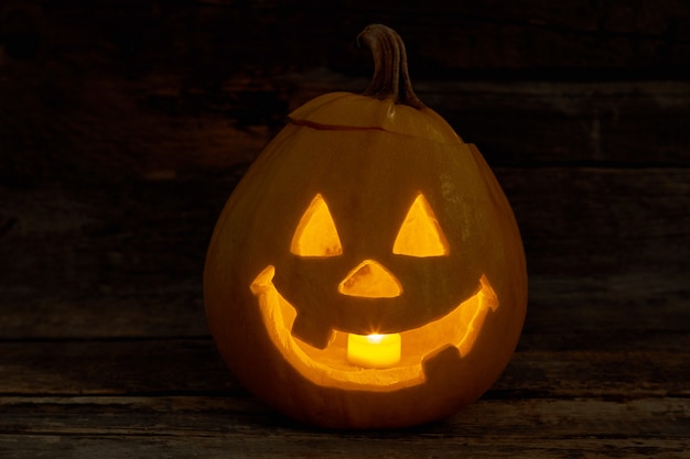 Süßer Halloween-Kürbis mit brennender Kerze Halloween-Kürbis-Jackolantern mit lustigem Ausdruck trad ...