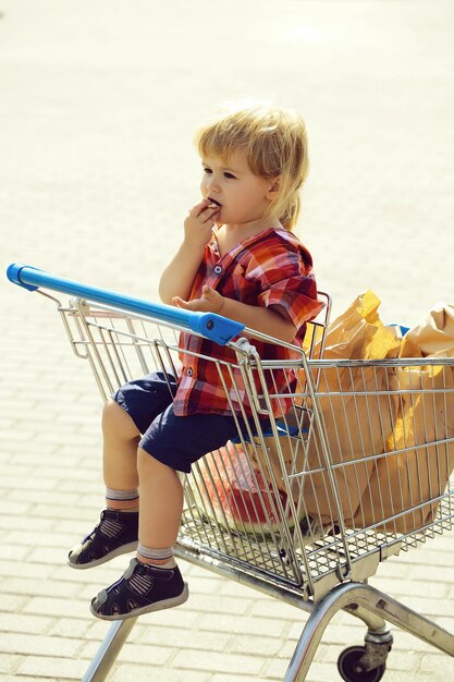 Süßer Junge im Einkaufswagen