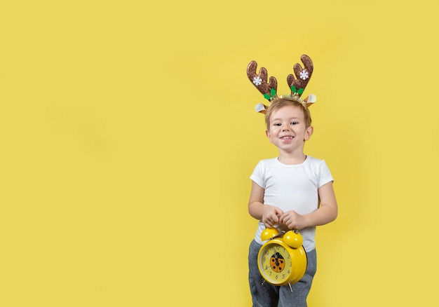 Süßer Junge im Weihnachtsrenkostüm, der lustige Gesichter macht