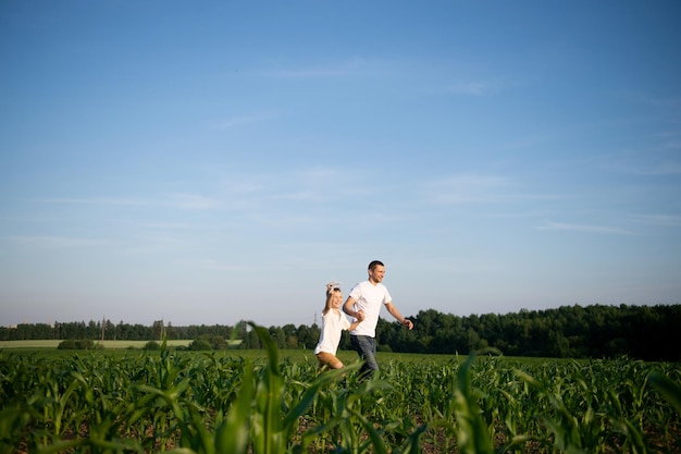 Süßer Junge in einem Maisfeld mit Papa, der ein Flugzeug startet