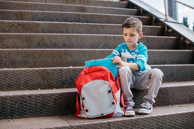 Foto süßer junge sitzt im freien