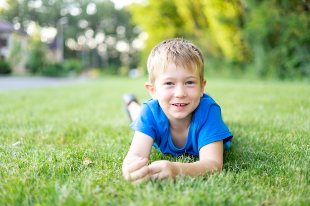 Süßer kleiner Junge, der im Sommer auf dem grünen Rasen im Park spielt. Kinderferien Erholung im Freien