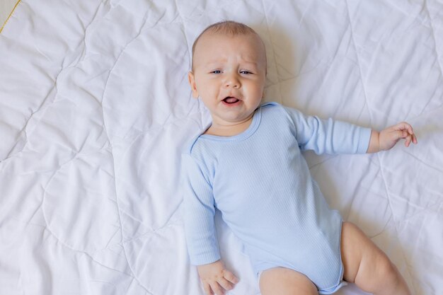 süßer kleiner junge im blauen körper, der auf decke, karte, banner, gesundheit, platz für text legt