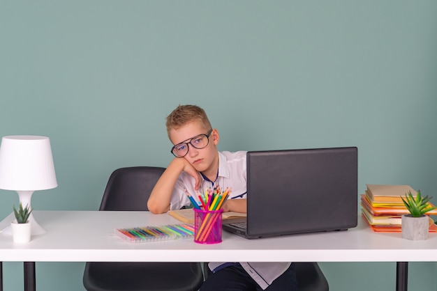 süßer kleiner Junge macht Hausaufgaben zu Hause online