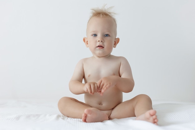 Foto süßer kleiner junge sitzt auf einem weißen hintergrund