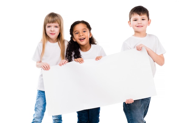süßer kleiner Junge und Mädchen mit einem leeren Papierblatt, isoliert auf weißem Hintergrund