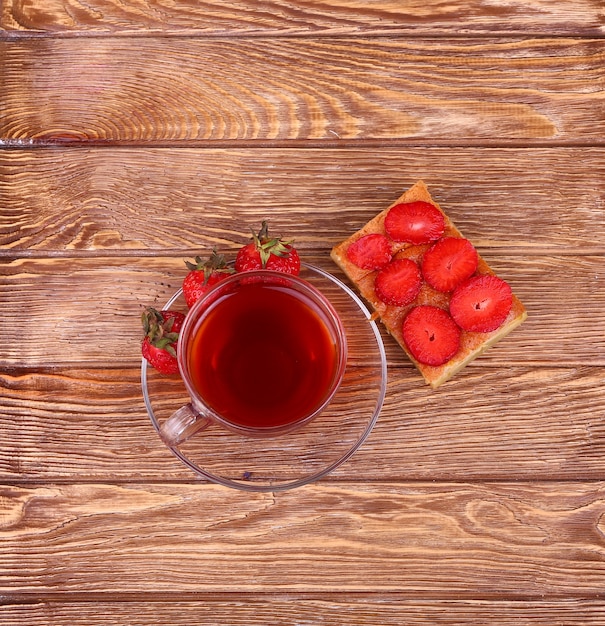 Süßer Kuchen mit Tasse Tee auf Holztisch