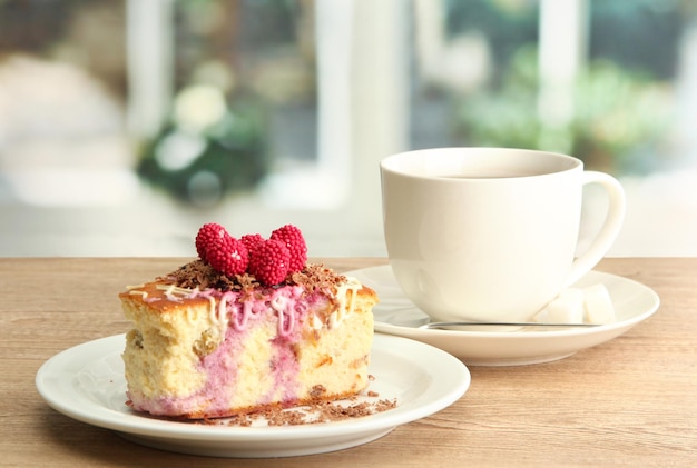 Süßer Kuchen mit Tasse Tee auf Holztisch