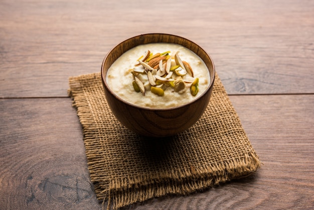 Süßer Rabdi oder Lachha Rabri oder Basundi, hergestellt aus reiner Milch, garniert mit Trockenfrüchten. Serviert in einer Schüssel über stimmungsvollem Hintergrund. Selektiver Fokus