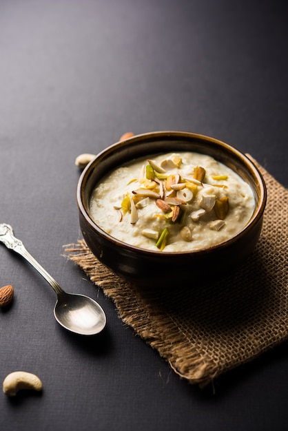 Süßer Rabdi oder Lachha Rabri oder Basundi, hergestellt aus reiner Milch, garniert mit Trockenfrüchten. Serviert in einer Schüssel über stimmungsvollem Hintergrund. Selektiver Fokus