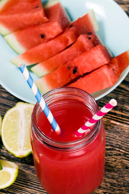 Süßer Wassermelonensaft aus Wassermelonen und Limetten- oder Zitronenstücken, roter Saft ist ein natürliches gesundes und diätetisches Produkt, Wassermelonensaft mit saurer Limette