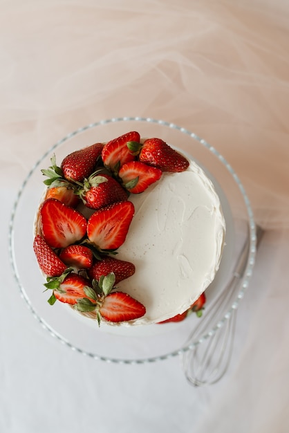 Süßer weißer Kuchen mit Sahne, garniert mit Erdbeeren auf einem Tablett