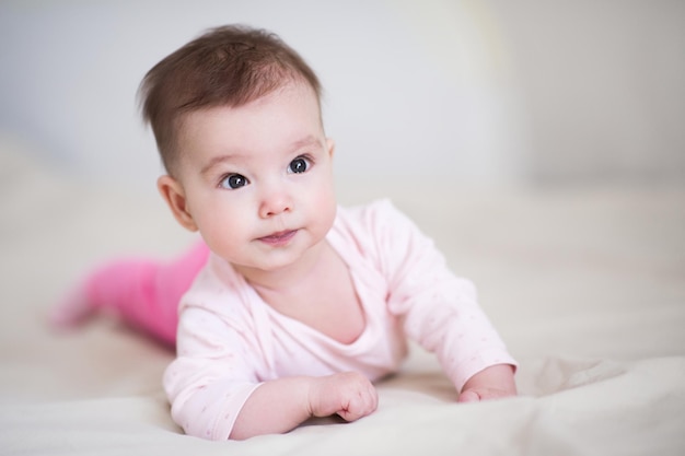 Süßes Baby unter 1 Jahr im Schlafanzug krabbelt im Bett