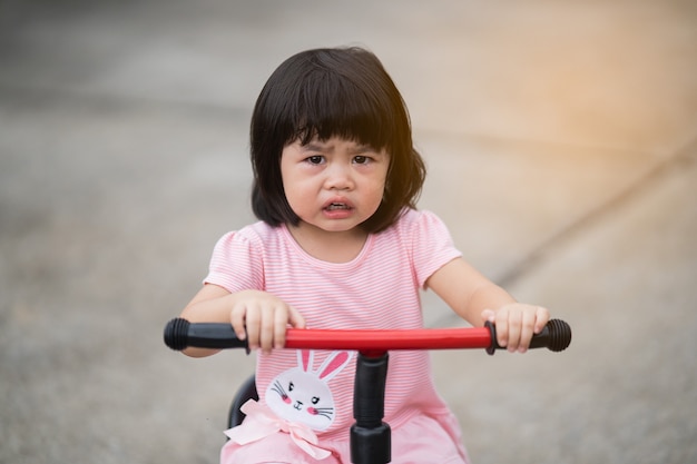 Süßes Baby weint und fährt Fahrrad
