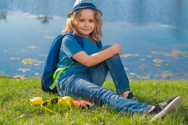 Süßes blondes Kind mit Fernglas mit Explorer-Hut und Rucksack in der Natur Child Explorer Wandern und Abenteuer