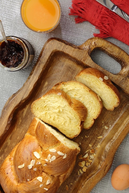 Süßes Brioche-Brot auf Tablett mit Saft und Marmelade