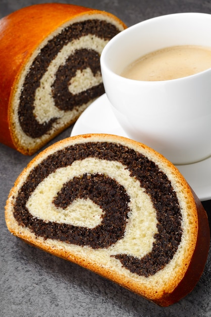 Süßes Brötchen gefüllt mit Mohn und Tasse Kaffee