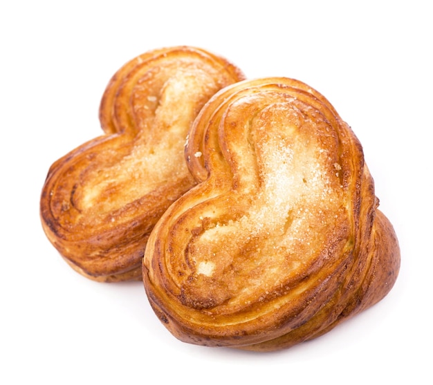 Süßes Brötchen mit appetitlichem Zimtbrötchen in Form von Herzen auf weißem Hintergrund