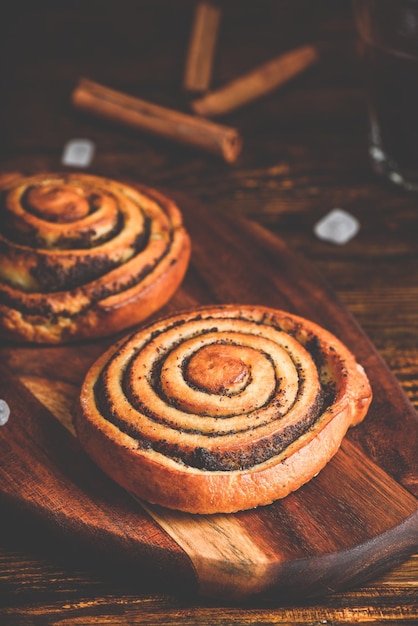 Süßes Brötchen mit Mohn. Glas schwarzer Kaffee und Zucker