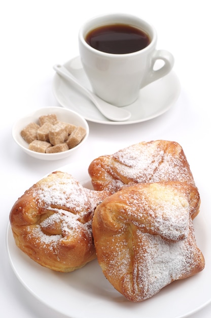 Süßes Brötchen und Tasse Kaffee auf weißem Hintergrund