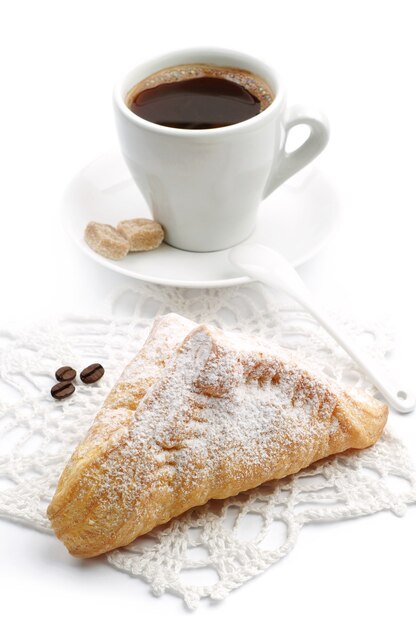 Süßes Croissant und Tasse Kaffee auf weißem Hintergrund