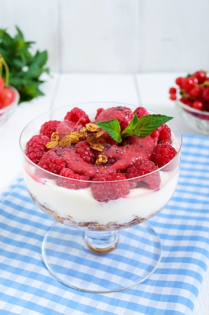 Süßes Dessert mit Müsli, Frischkäse und Himbeeren