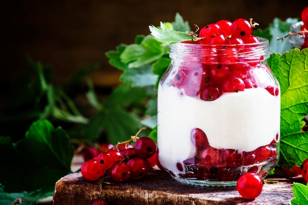 Süßes Dessert mit rotem Johannisbeer-Hüttenkäse und Joghurtmousse Vintage Holzhintergrund selektiver Fokus