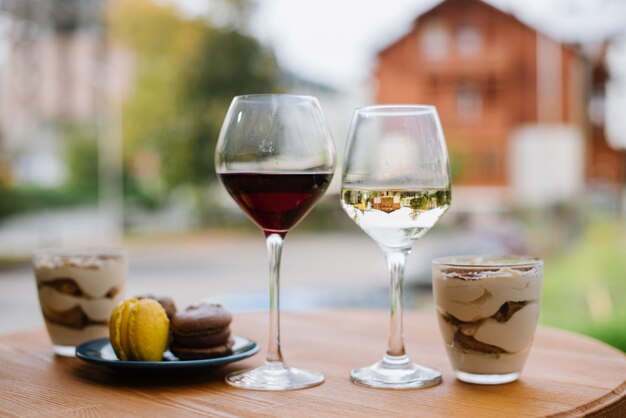 Süßes Dessert Tiramisu und ein Glas Wein im Freien auf der Restaurantterrasse