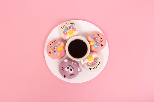 Süßes Essen und eine Tasse Kaffee auf rosa Hintergrund Speisen und Getränke