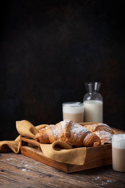 Süßes frisches Croissant und Milch oh der Holztisch, selektiver Fokus