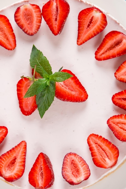 Süßes Frühstück köstlicher Käsekuchen mit frischen Erdbeeren und hausgemachtem Minzrezept ohne Backen auf einem dunkelblauen Steintisch Kopierraum