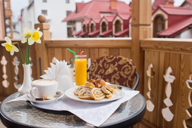 Süßes Frühstück mit Kaffee auf dem Balkon mit Blick ins Freie