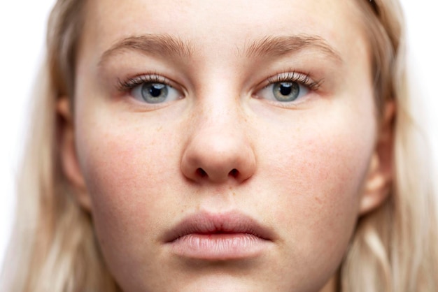 Süßes Gesicht eines Teenagermädchens mit Freckles Blondin mit neutralen Emotionen Weißer Hintergrund Nahaufnahme