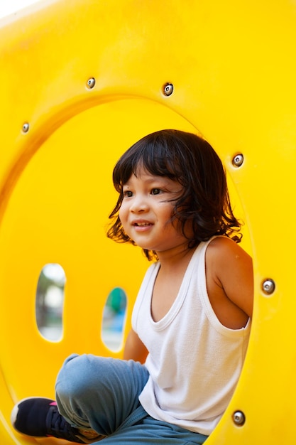 süßes kind, das rutsche auf dem spielplatz spielt