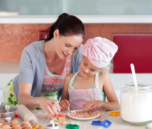 Süßes kleines Mädchen, das ihrer Mutter ihre Plätzchen zeigt