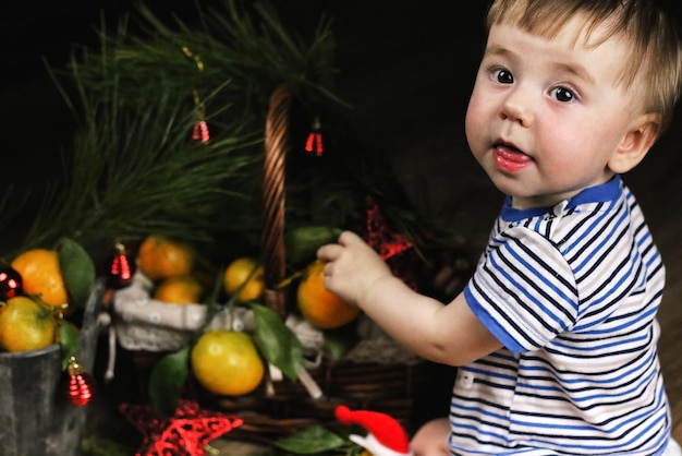 Süßes kleines Mädchen im Kleid mit Weihnachtskorb