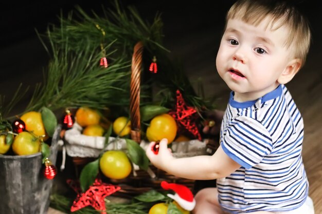 Süßes kleines Mädchen in einem Kleid mit Weihnachtskorb